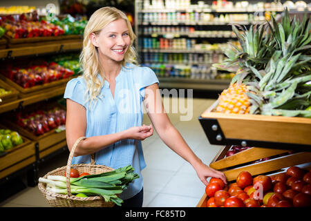 Femme souriante en tenant tomates Banque D'Images