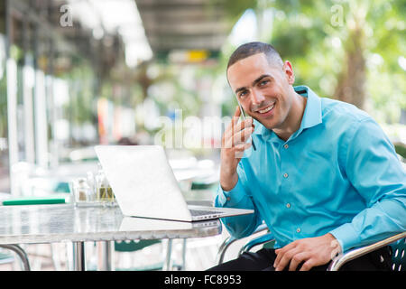 Caucasian businessman talking on cell phone in cafe Banque D'Images