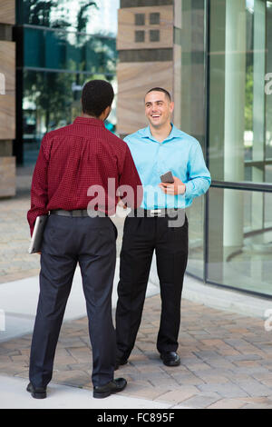 Businessmen shaking hands outdoors Banque D'Images