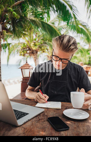 Man writing in cafe Banque D'Images