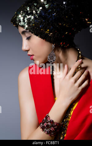 Femme à la mode concept dans studio sombre Banque D'Images