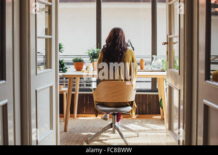 Caucasian woman sitting at desk Banque D'Images