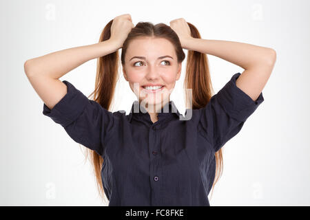 Heureux amusant jeune femme avec deux queues s'amusant sur fond blanc Banque D'Images