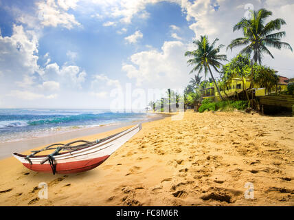 Petit bateau sur une plage de l'océan au Sri Lanka Banque D'Images