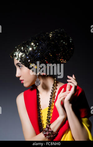 Femme à la mode concept dans studio sombre Banque D'Images