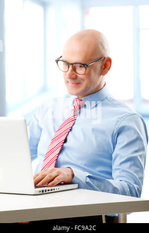 Portrait d'efficacité conseiller financier l'analyse des données à l'ordinateur tout en étant assis au bureau. Banque D'Images