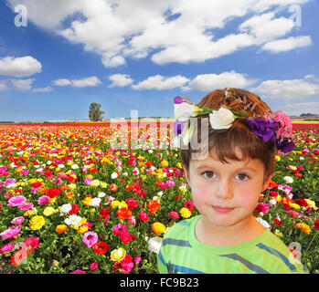 Le charmant petit garçon en guirlande de fleurs Banque D'Images