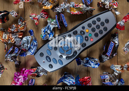 Télécommande du téléviseur entouré par des papillotes à Noël. Banque D'Images