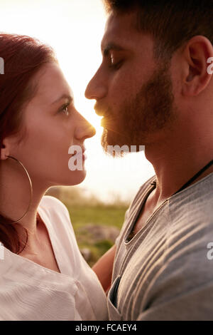 Close up image of young couple in love embrassant et à la recherche dans chaque autres yeux romantiquement. Young couple outdo Banque D'Images