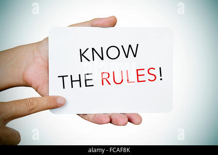 Gros plan des mains d'un jeune homme montrant une pancarte avec le texte connaître les règles Banque D'Images