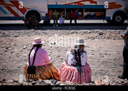 Deux femmes attendent sur le côté alors que leur bus est réparé dans le Salar de Uyuni, Bolivie. Banque D'Images