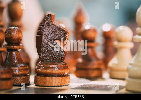 Old Brown Chess Knight et pions debout sur échiquier en bois Banque D'Images