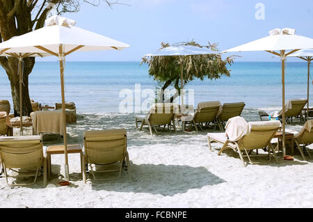 Parasols et chaises longues blanc sur la plage en Grèce. Banque D'Images