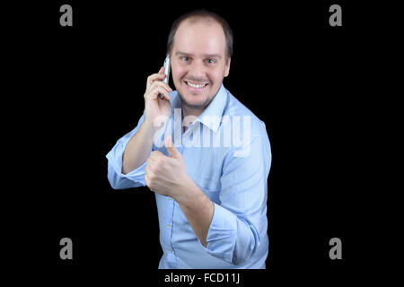 Young man smiling parler mobile phone Thumbs up Banque D'Images