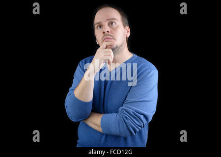 Jeune homme chemise bleue pensant holding chin Banque D'Images
