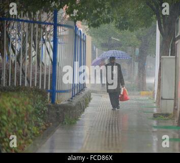 Jiujiang, Chine, province de Jiangxi. 22 janvier, 2016. Les gens marchent dans une rue de la ville de Jiujiang, province de Jiangxi en Chine orientale, le 22 janvier 2016. Une grande partie de Jiangxi a été frappé par les tempêtes de neige vendredi. C'est le temps le plus froid depuis 1992 est prévu de Janvier 23 à 26. Credit : Hu Chenhuan/Xinhua/Alamy Live News Banque D'Images