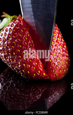 Faire cuire les fraises coupées dans un bureau en verre. Banque D'Images