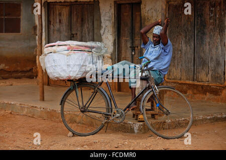 Stone Town (Zanzibar), Tanzanie - 10 janvier 2016 : un homme adulte avec un vélo sur fond de vieux mur à Stone Town, Zanzibar. Banque D'Images