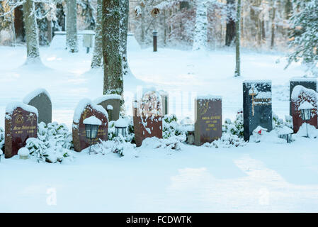 Ronneby, Suède - le 20 janvier 2016 : pierres tombales dans un paysage d'hiver avec forêt en arrière-plan. Dans Bredakra au cimetière Banque D'Images