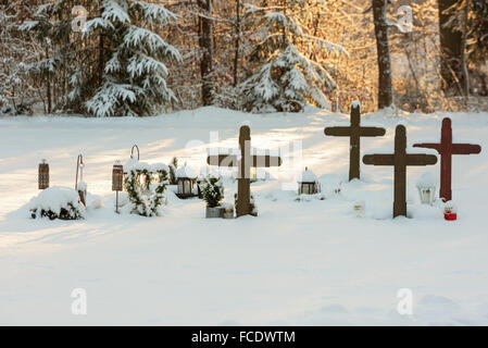 Ronneby, Suède - le 20 janvier 2016 : Croix dans un paysage d'hiver avec forêt en arrière-plan. Dans Bredakra cimetière en Ron Banque D'Images