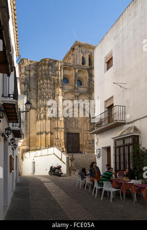 Café de la rue étroite et église de Santa Maria de la Asuncion, Arcos de la Frontera, province de Cadiz, Espagne Banque D'Images