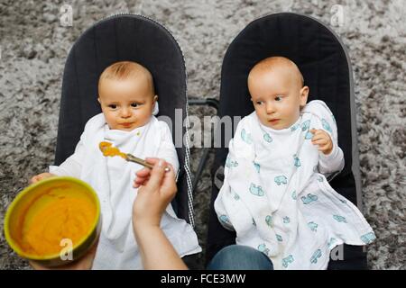 Une mère allaiter son bébé jumeaux garçon 8 mois Banque D'Images