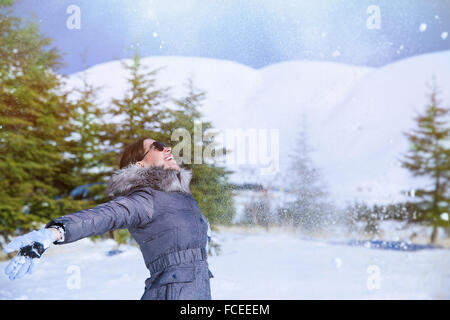 Femme heureuse dans le parc en de la neige dans l'air, en vertu de l'article neige et avec plaisir jusqu'à la recherche, heureux vacances d'hiver Banque D'Images