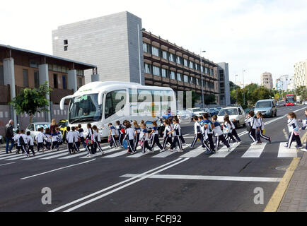 Les écoliers cross road à l'attente coach à Santa Cruz de Tenerife, Canaries, Espagne Banque D'Images