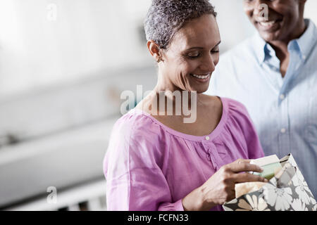 Une affectueuse African American couple mature, avec leurs bras autour de l'autre dans leur maison. Banque D'Images