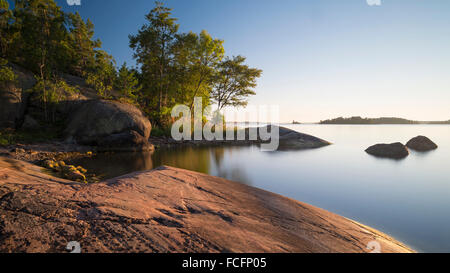 Côte Rocheuse dans une petite baie de l'île de l'archipel Yxlan près de Stockholm en Suède dans la lumière du soir chaud Banque D'Images