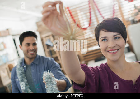 Décorations de Noël. Un homme et femme tenant guirlandes et décorations. Banque D'Images