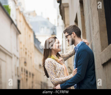 Un couple debout à regarder les uns les autres, dans une rue étroite dans une ville. Banque D'Images