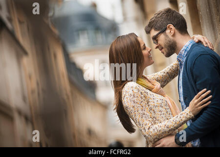 Un couple debout à regarder les uns les autres, dans une rue étroite dans une ville. Banque D'Images