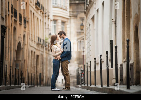 Un couple debout à regarder les uns les autres, dans une rue étroite dans une ville. Banque D'Images