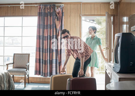 Un jeune couple arrivant dans une chambre de motel. Banque D'Images