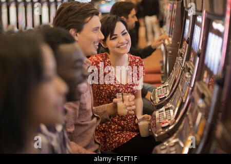 Un groupe de personnes qui jouent aux machines à sous dans un casino. Banque D'Images