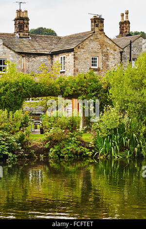 Vieux chalets à côté de la rivière Wye de Bakewell, Derbyshire, Angleterre, Royaume-Uni. Banque D'Images