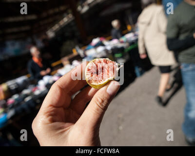 La moitié d'une petite rose et vert fig dans la main de femme au marché Markale à Sarajevo, Bosnie et Herzégovine, l'Europe. Banque D'Images