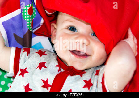 Baby smiling et l'emballage lui-même dans son tapis de jeu Banque D'Images