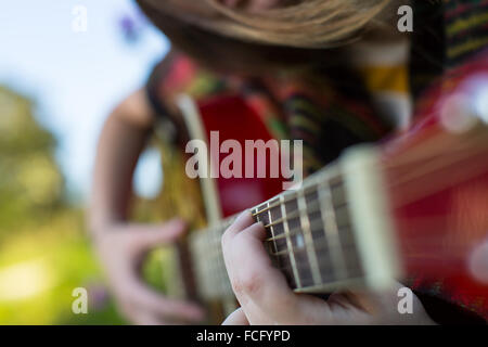 Les doigts sur les cordes close up, girl playing acoustic guitar. Banque D'Images