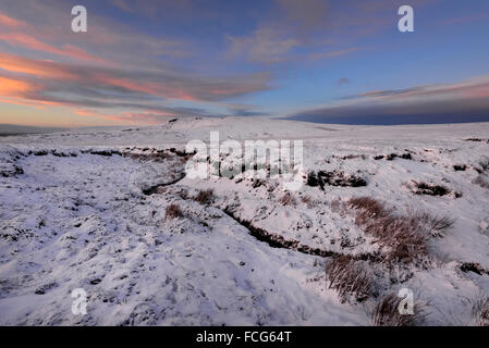 Moorland Snowy à côté du Pennine Way dans le Derbyshire Glossop ci-dessus sur une magnifique soirée d'hiver au coucher du soleil. Banque D'Images