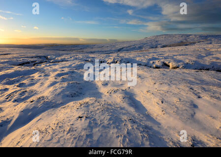 Moorland Snowy à côté du Pennine Way dans le Derbyshire Glossop ci-dessus sur une magnifique soirée d'hiver au coucher du soleil. Banque D'Images