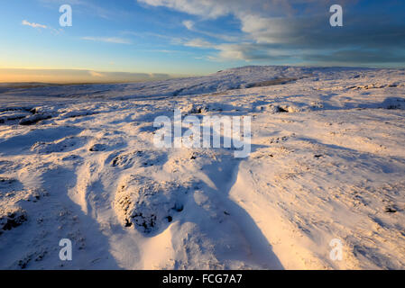 Moorland Snowy à côté du Pennine Way dans le Derbyshire Glossop ci-dessus sur une magnifique soirée d'hiver au coucher du soleil. Banque D'Images