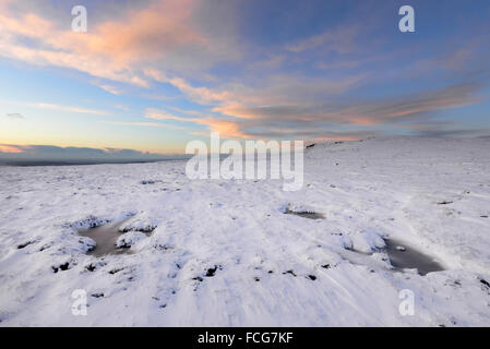 Moorland Snowy à côté du Pennine Way dans le Derbyshire Glossop ci-dessus sur une magnifique soirée d'hiver au coucher du soleil. Banque D'Images