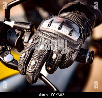 Main humaine dans une course de moto Moto Gants est titulaire d'une commande d'accélération. Protection des mains contre les chutes et les accidents. Banque D'Images