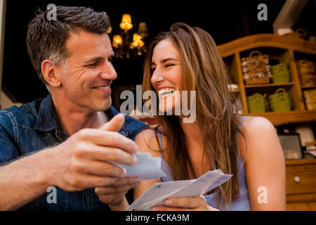 Happy couple looking at postcards Banque D'Images