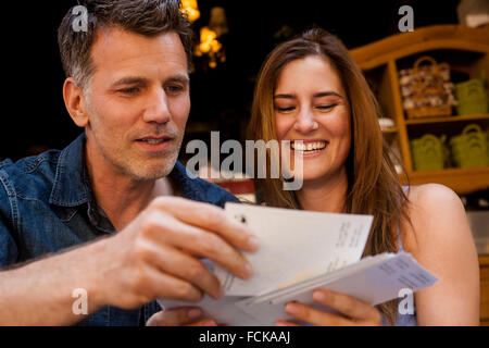 Happy couple looking at postcards Banque D'Images