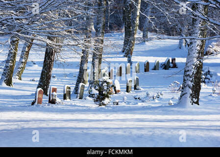 Ronneby, Suède - le 20 janvier 2016 : Bredakra cimetière à Ronneby. Voici quelques pierres tombales se tenir dans le paysage couvert de neige fermer Banque D'Images