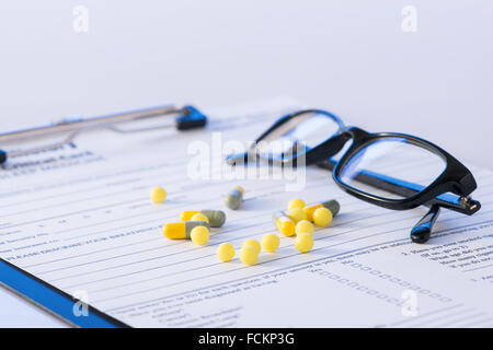 Comprimés et les lunettes sur le haut de forme de l'hôpital. Banque D'Images