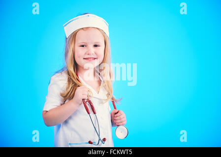 Belle blonde médecin, infirmière sur un fond bleu avec un stéthoscope. Banque D'Images